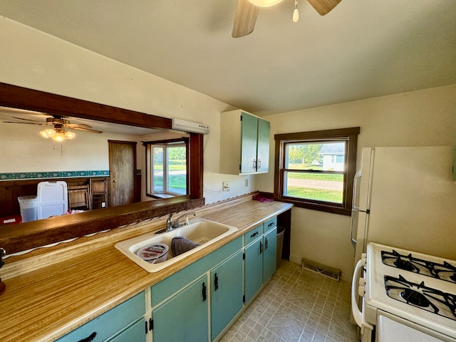 kitchen with white appliances, ceiling fan, a healthy amount of sunlight, and sink