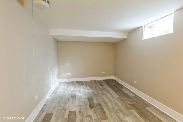 basement with baseboards and wood finished floors