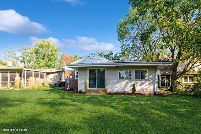 back of house with a lawn and a sunroom