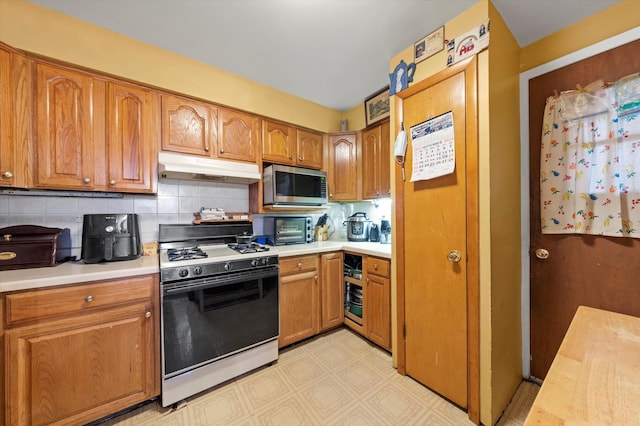 kitchen with gas stove and tasteful backsplash