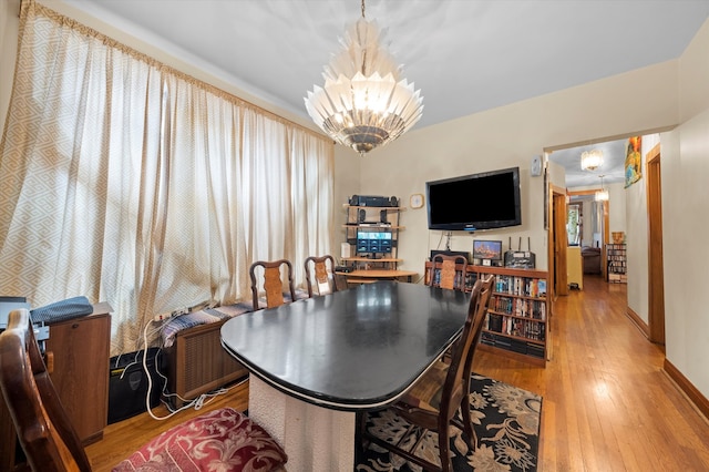 dining area featuring hardwood / wood-style floors and a chandelier