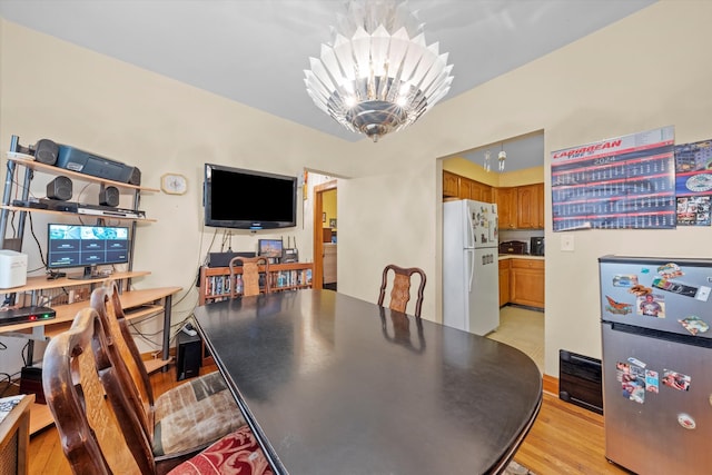 dining area with a notable chandelier and light hardwood / wood-style floors