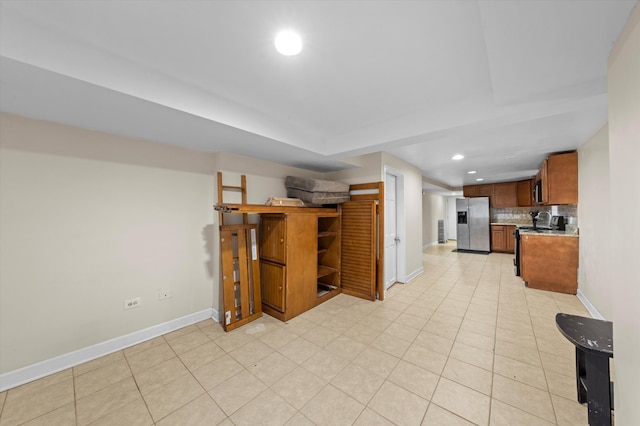 kitchen featuring stainless steel refrigerator with ice dispenser, light tile patterned flooring, and decorative backsplash