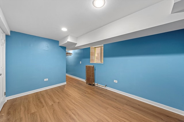 basement with wood-type flooring and radiator