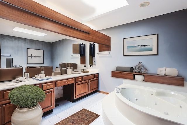 bathroom featuring tiled tub, a skylight, vanity, and tile patterned floors