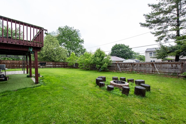 view of yard featuring a wooden deck and a fire pit