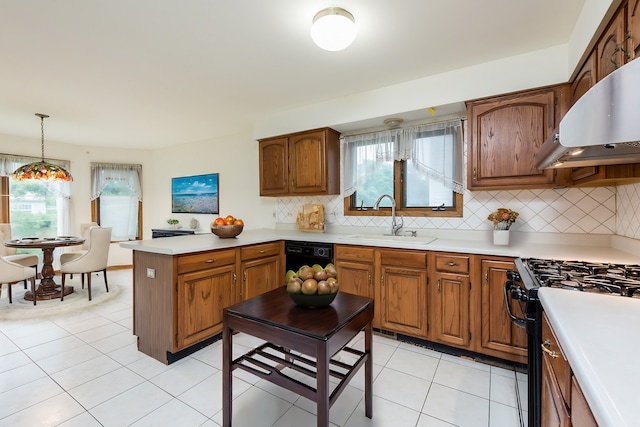 kitchen featuring decorative backsplash, light tile patterned flooring, range with gas cooktop, decorative light fixtures, and sink