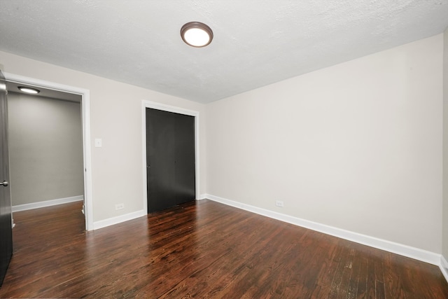 interior space with a textured ceiling and dark wood-type flooring