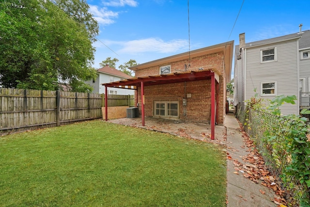 rear view of house featuring a lawn, a pergola, central air condition unit, and a patio area