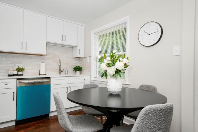 kitchen featuring dark wood-type flooring, white cabinetry, decorative backsplash, and stainless steel dishwasher