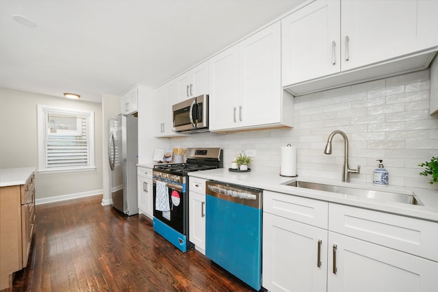 kitchen featuring tasteful backsplash, sink, white cabinetry, appliances with stainless steel finishes, and dark hardwood / wood-style flooring