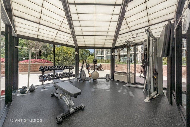 gym featuring a wall of windows and vaulted ceiling