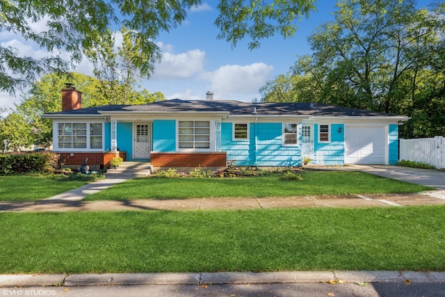 ranch-style home featuring a garage and a front lawn