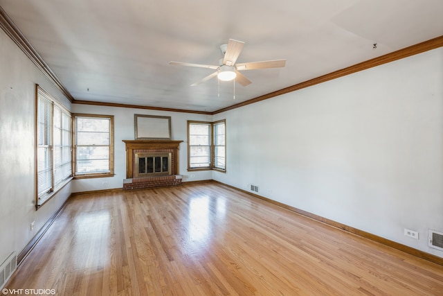 unfurnished living room with light hardwood / wood-style flooring, ornamental molding, ceiling fan, and a fireplace