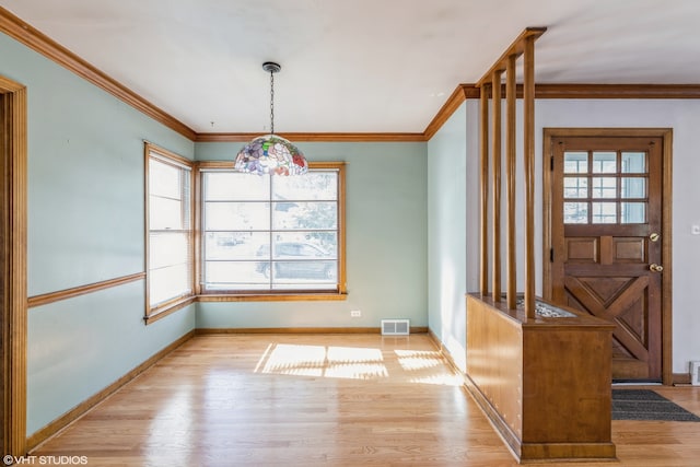 unfurnished dining area with crown molding and light hardwood / wood-style floors