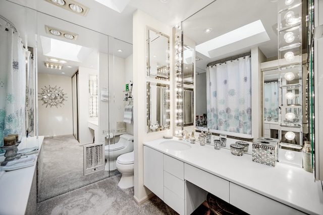 bathroom featuring vanity, toilet, and a skylight