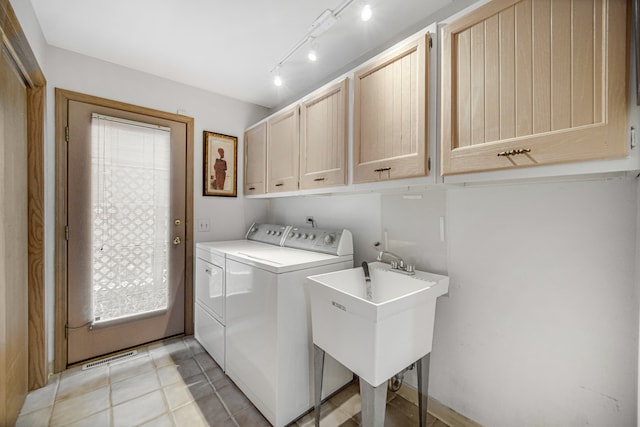 laundry room featuring cabinets, sink, and washing machine and dryer