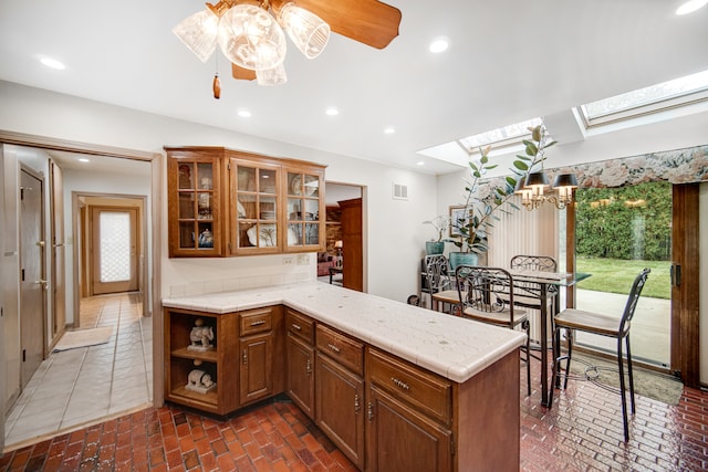 kitchen featuring kitchen peninsula, a skylight, and plenty of natural light