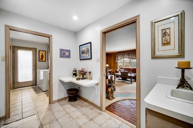 bathroom with sink, tile patterned flooring, and washing machine and clothes dryer