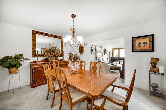 dining space featuring an inviting chandelier and light colored carpet