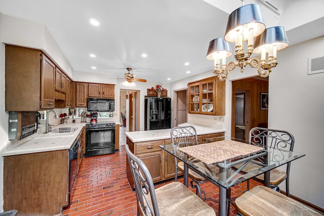 kitchen with black appliances, sink, ceiling fan with notable chandelier, hanging light fixtures, and decorative backsplash