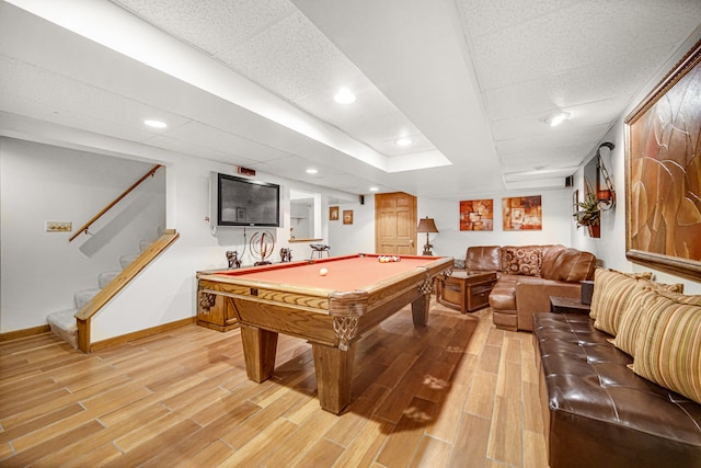 rec room featuring a tray ceiling, hardwood / wood-style flooring, and billiards