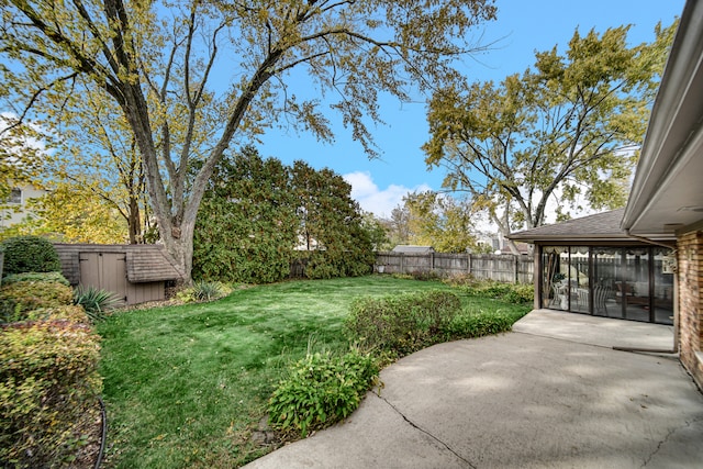 view of yard featuring a sunroom, a patio area, and a shed