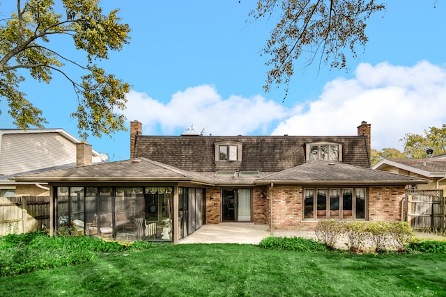 back of house featuring a patio, a sunroom, and a lawn