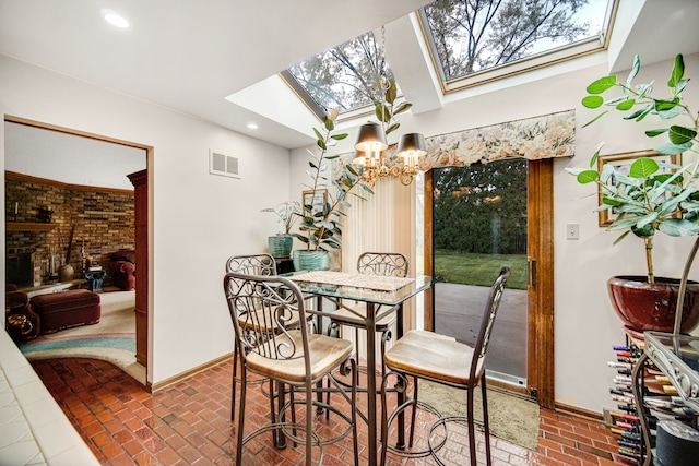 dining room with a notable chandelier and lofted ceiling with skylight