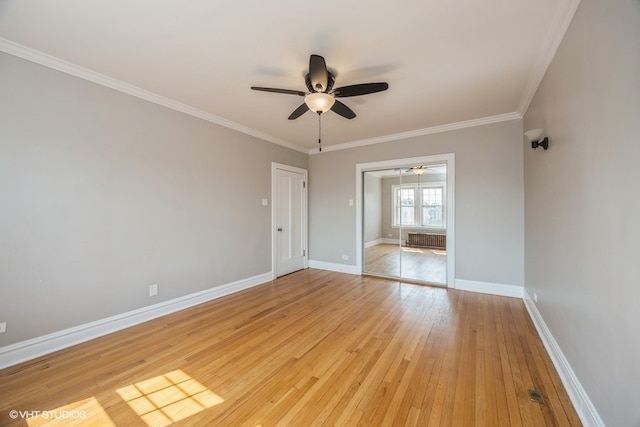 spare room featuring light hardwood / wood-style flooring, ceiling fan, ornamental molding, and radiator heating unit