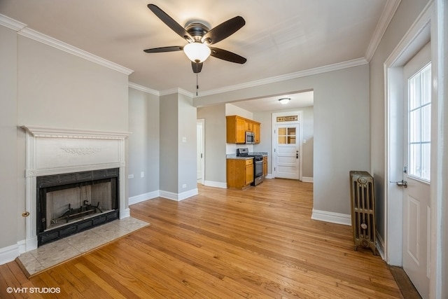 unfurnished living room with ornamental molding, light wood-type flooring, ceiling fan, and radiator heating unit