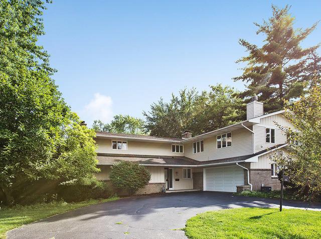 1516 Southlawn Pl, Aurora, IL 60506 - view of front of property featuring brick siding, a garage, driveway, and a chimney