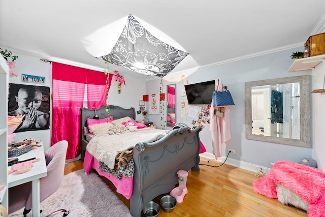 bedroom featuring wood-type flooring and ornamental molding