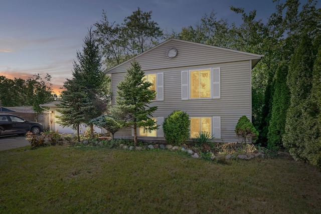 property exterior at dusk with a lawn