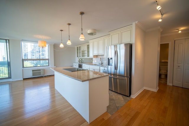 kitchen featuring light wood-type flooring, hanging light fixtures, stainless steel fridge with ice dispenser, and tasteful backsplash