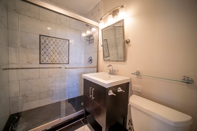 bathroom featuring vanity, toilet, and a shower with door