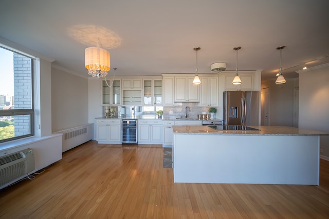 kitchen featuring stainless steel fridge, sink, beverage cooler, decorative light fixtures, and light hardwood / wood-style floors