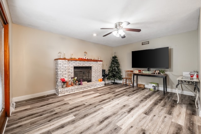 living room with ceiling fan, hardwood / wood-style flooring, and a fireplace