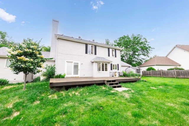 rear view of house featuring a yard and a wooden deck