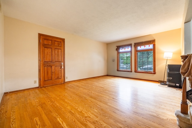 unfurnished living room featuring a textured ceiling and light wood-type flooring