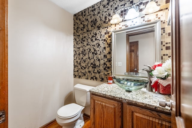 bathroom featuring tile walls, hardwood / wood-style floors, vanity, and toilet