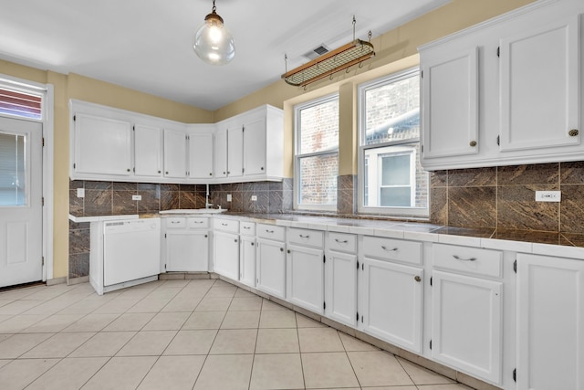 kitchen with pendant lighting, white dishwasher, and white cabinetry