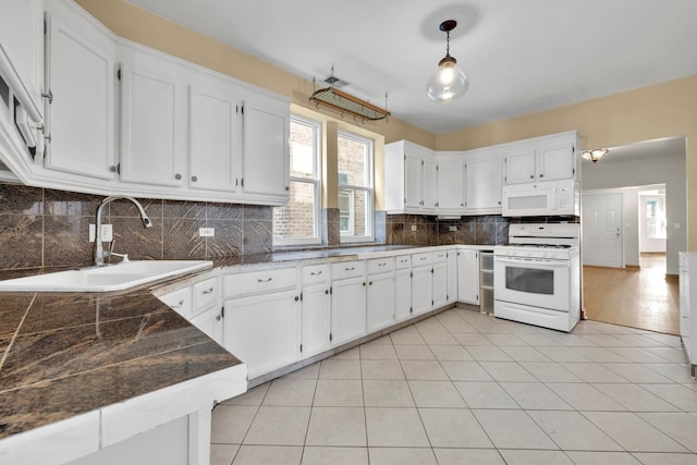 kitchen featuring decorative light fixtures, backsplash, white appliances, and white cabinetry