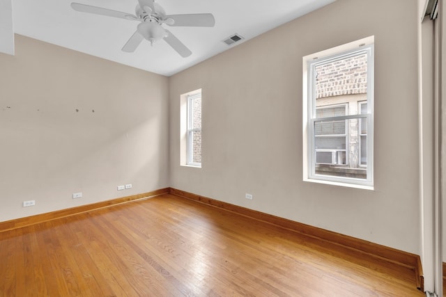 unfurnished room with light wood-type flooring, ceiling fan, and plenty of natural light