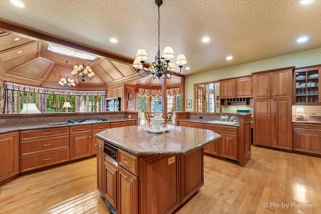 kitchen featuring light hardwood / wood-style floors, hanging light fixtures, a center island, and an inviting chandelier