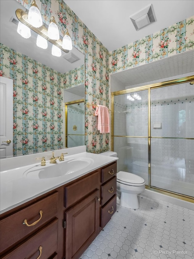 bathroom with toilet, a shower with door, and vanity