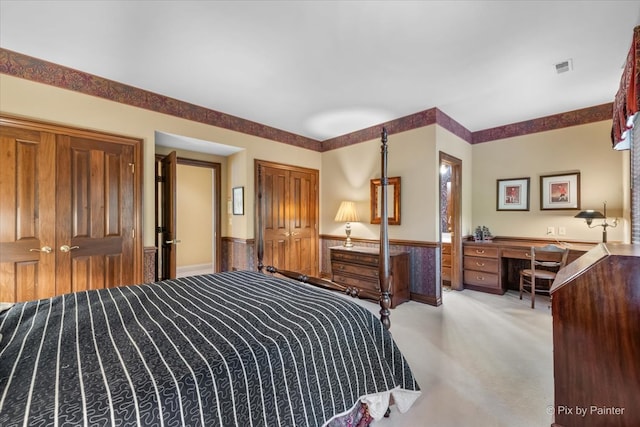 carpeted bedroom with a closet and built in desk