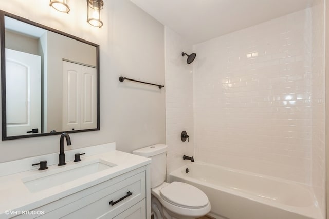 full bathroom featuring vanity, tiled shower / bath, and toilet