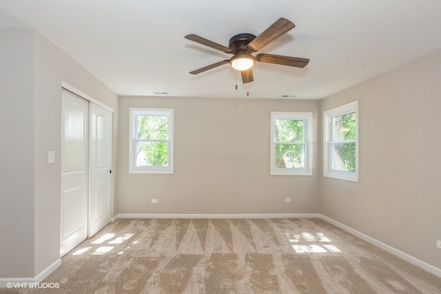 empty room featuring ceiling fan and light carpet