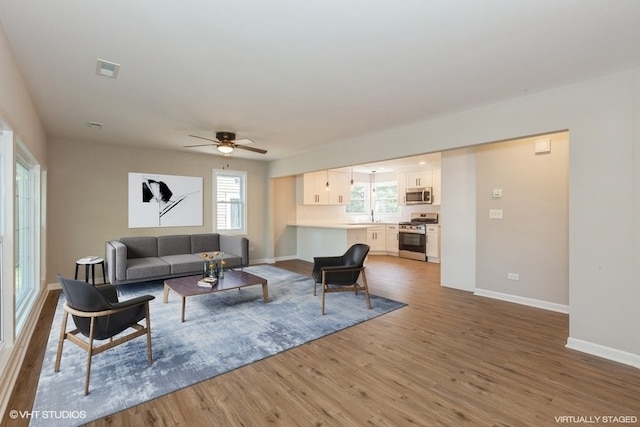 living room with ceiling fan and hardwood / wood-style flooring